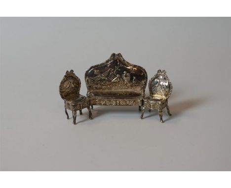 An Edward VII hallmarked silver three piece dolls house miniature suite, comprising a two seater sofa and two chairs, each wi