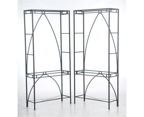 A pair of painted wrought metal shelf units each of upright rectangular form with arched centres complete wiht plate glass sh