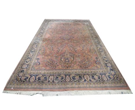A Persian patterned carpet, the dark red ground with guard stripes with a flower and leafy border, a central medallion centre