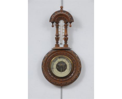 A Victorian walnut cased wheel barometer with a 9cm enamel dial above a mercury thermometer, the case with an arched top and 