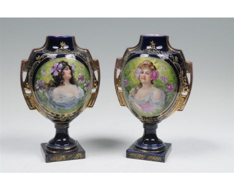 A pair of continental Vienna style cobalt blue and gilt portrait vases each decorated with maidens raised upon plinth bases, 