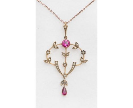 An early 20th century Art Nouveau pendant, of open scrolling form, the central round cut synthetic ruby to floral swags set w