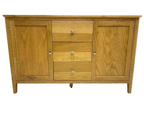 Contemporary light oak sideboard, fitted with three central drawers flanked by two panelled cupboards, on tapering supportsDi