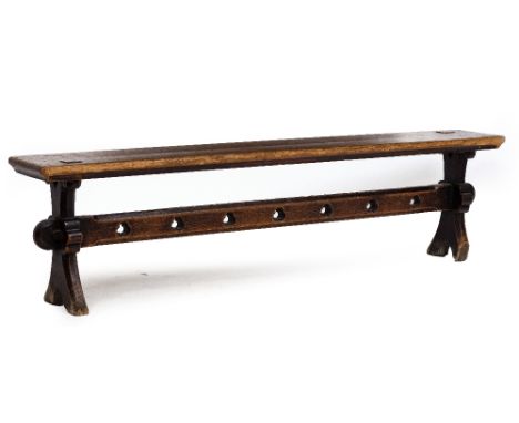 A VICTORIAN OAK BENCH with shaped end supports and trefoil decoration to the pierced stretcher, approximately 184cm long x 30