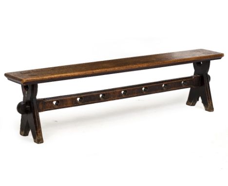 A VICTORIAN OAK BENCH with shaped end supports and trefoil decoration to the pierced stretcher, approximately 184cm long x 30