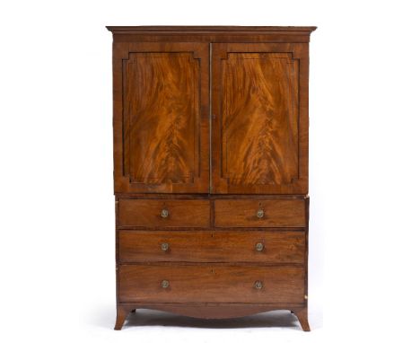 A 19TH CENTURY MAHOGANY LINEN PRESS with twin panelled doors above two short and two long drawers with brass handles and spla