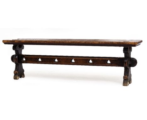 A VICTORIAN OAK BENCH with shaped end supports and trefoil decoration to the pierced stretcher, approximately 184cm long x 30