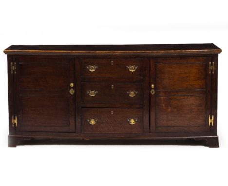 A 19TH CENTURY OAK DRESSER BASE with two panelled doors and three central drawers, on bracket feet, 180cm x 45cm x 82cm At pr