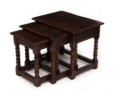 A NEST OF THREE MODERN OAK RECTANGULAR OCCASIONAL TABLES with bobbin and reel turned legs and of pegged construction, the lar