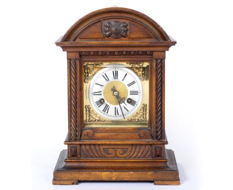 AN EDWARDIAN WALNUT CASED MANTLE CLOCK with a brass and silver dial, having roman numerals, to include a key and pendulum, 25