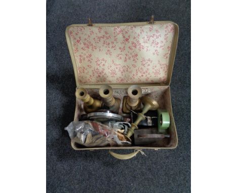 A vintage luggage case of antique iron, brass candlesticks, mid century mantel clock, gloves etc 
