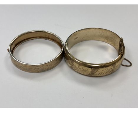 A vintage rolled gold bangle together with a white metal bangle with textured decoration. (2)