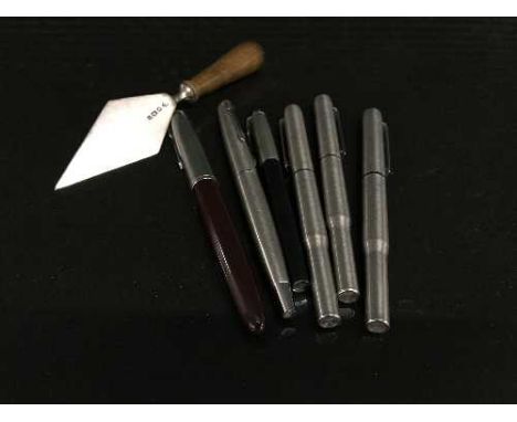 A silver miniature trowel and a collection of assorted pens 