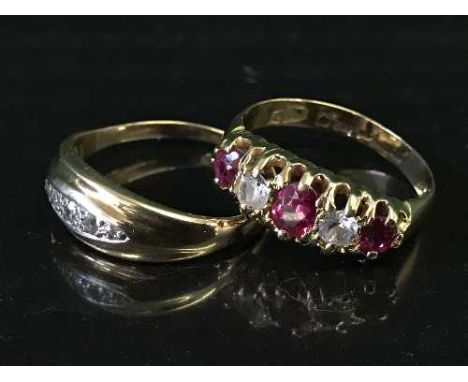 An 18ct gold ruby set ring together with a three stone diamond ring. (2)