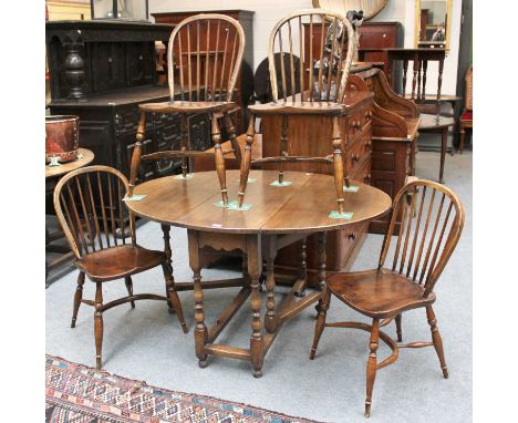 A 20th Century Oak Gate Leg Table, 133cm by 107cm by 74cm, and a set of four Windsor side chairs with crinoline stretchers (5