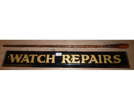 Bamboo sword stick and a wooden watch repairs advertising board