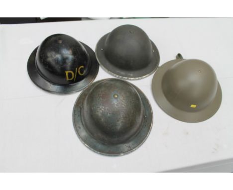 Second World War British Military tin helmet stamped - 1939, painted D / C on top, together with another dated 1940 and two o