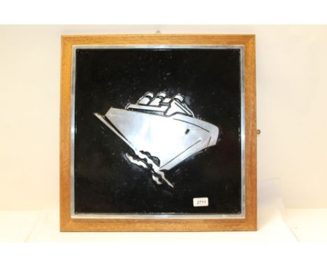 Square cast metal engine name plate decorated with a stylistic image of a liner against a black background and mounted on a w