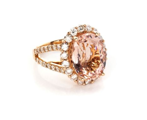 A DIAMOND AND MORGANITE RING centred by an oval claw-set mixed-cut morganite, weighing approximately 12ct, surrounded by 18 p