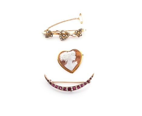 A DIAMOND AND RUBY BROOCH designed as a crescent moon set with 24 pavé-set old-cut diamonds interspersed with 13 oval-cut rub