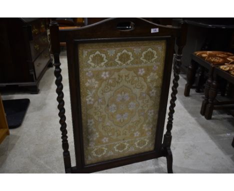 An oak firescreen having needlework inset
