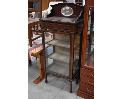 An Edwardian mahogany and inlaid narrow display cabinet having mirror back and frieze drawer, glass damaged on one side panel