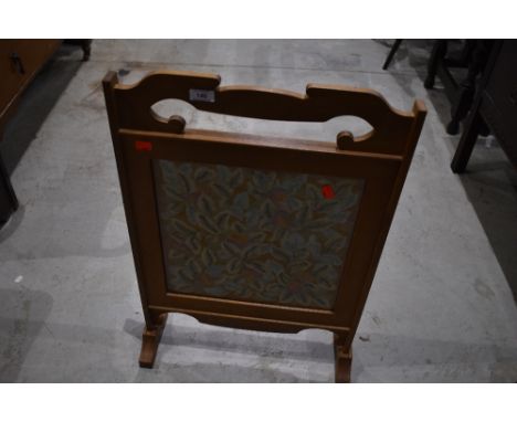A golden oak firescreen having woolwork inset, width approx. 47cm