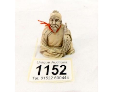 A 19th century netsuke of a Chinese gentleman with a fish