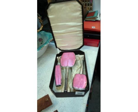 A cased pink enamel vanity set