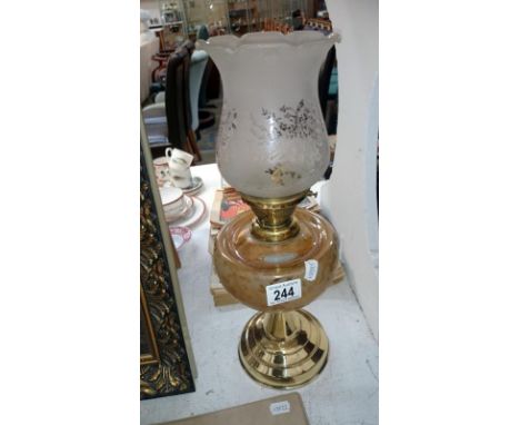 A brass oil lamp with frosted glass font and acid etched shade