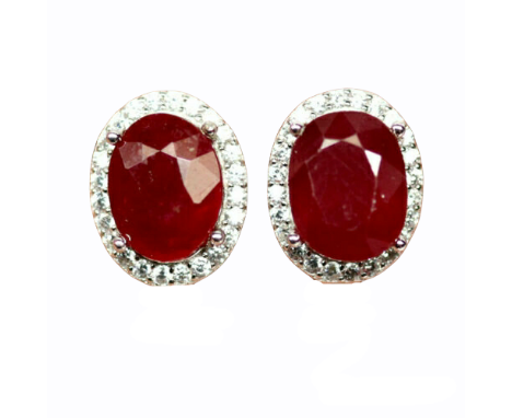 A pair of 925 silver earrings set with an oval cut ruby surrounded by white stones, L. 1.5cm.