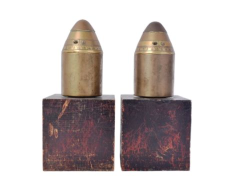 A pair of bookends fashioned from two WWI First World War artillery shell fuses. Each mounted atop a custom made brass body, 