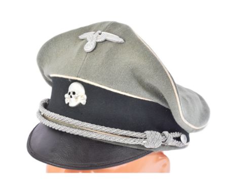 A WWII Second World War related Third Reich Nazi German Waffen SS Officer's peaked cap. The green felt hat having a black cen