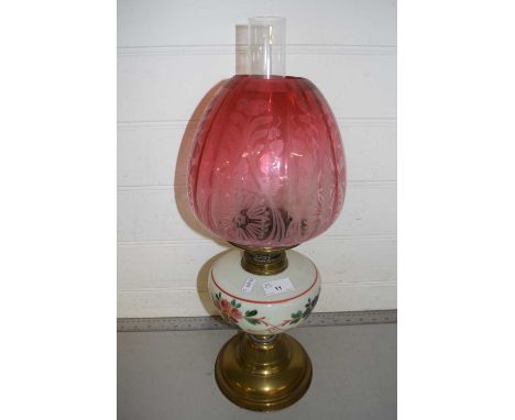 Brass based oil lamp with cranberry tinted shade