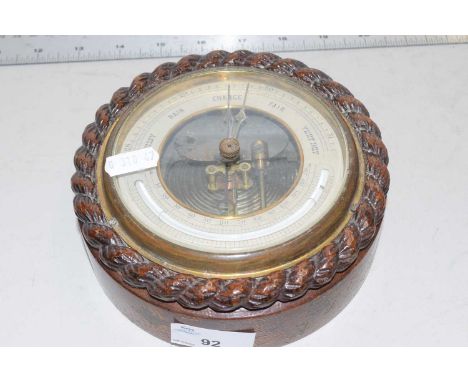 A small barometer in oak case with rope carved decoration
