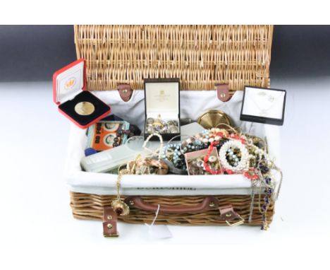 A collection of vintage and contemporary costume jewellery contained within a wicker basket. 