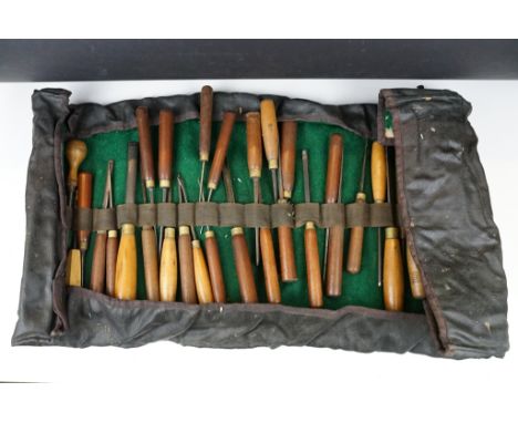 Collection of 39 vintage woodworking chisels, wooden handled, contained within a roll-up case 