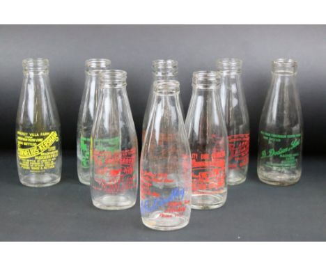 Set of eight vintage glass milk bottles complete with advertising to the sides. 