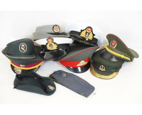 A collection of ten military caps and berets together with associated badges to include Ukraine Army, Pakistan Navy, Indian N