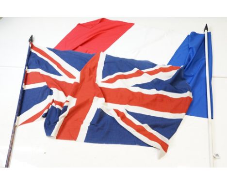 Two large flags on poles to include a vintage Union Jack cloth flag and a French tricolour example. (Flags measure approx 165