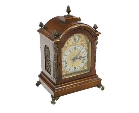 An attractive Edwardian oak cased Mantle Clock, the domed top with multiple brass finials above an arched brass and silver di