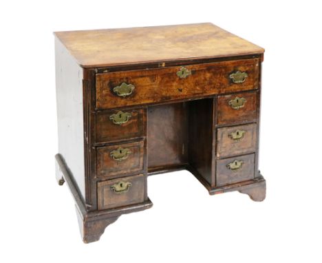 An early Georgian period walnut and feather banded kneehole Desk, the top probably associated above a wide frieze drawer abov
