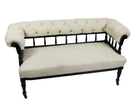 An Aesthetic movement ebonised Settee, with padded button top raised on a balustrade support above a padded seat on turned le