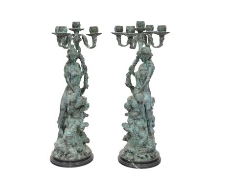 A large pair of bronzed metal figural Candelabra, each with four arms and a centre light (one arm missing) each modelled as a