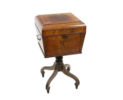 A Regency period mahogany Teapoy, the casket shaped top opening to reveal a fitted interior with three caddies and a metal mi