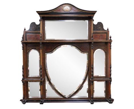 An Aesthetic movement ebonised and gilt Overmantel, the arch cornice with central painted porcelain panel of a cherub above l