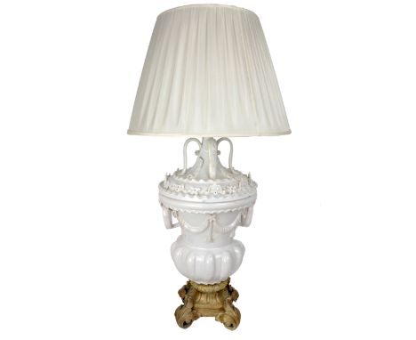 A large vase shaped cream ceramic Table Lamp, with two handles, drapes and tassels above a reeded body on attractive cast gil