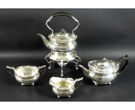 A George V four piece silver tea set comprising tea pot, milk jug, sucrier and spirit kettle on stand, all faceted boat forms