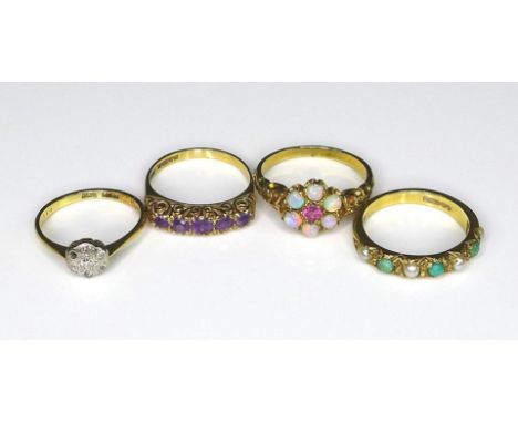 A group of four Victorian/Edwardian 9ct gold rings, comprising a flowerhead ring set with six opals and a ruby, scrolling lea