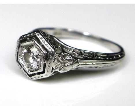 An 18ct white gold and diamond Art Deco style solitaire ring, the 0.25ct diamond within a hexagonal setting, scrolling fan de